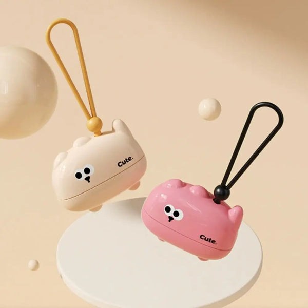 A pink reusable pet hair roller with a cute animal design and a gold-colored handle is shown on a white surface.