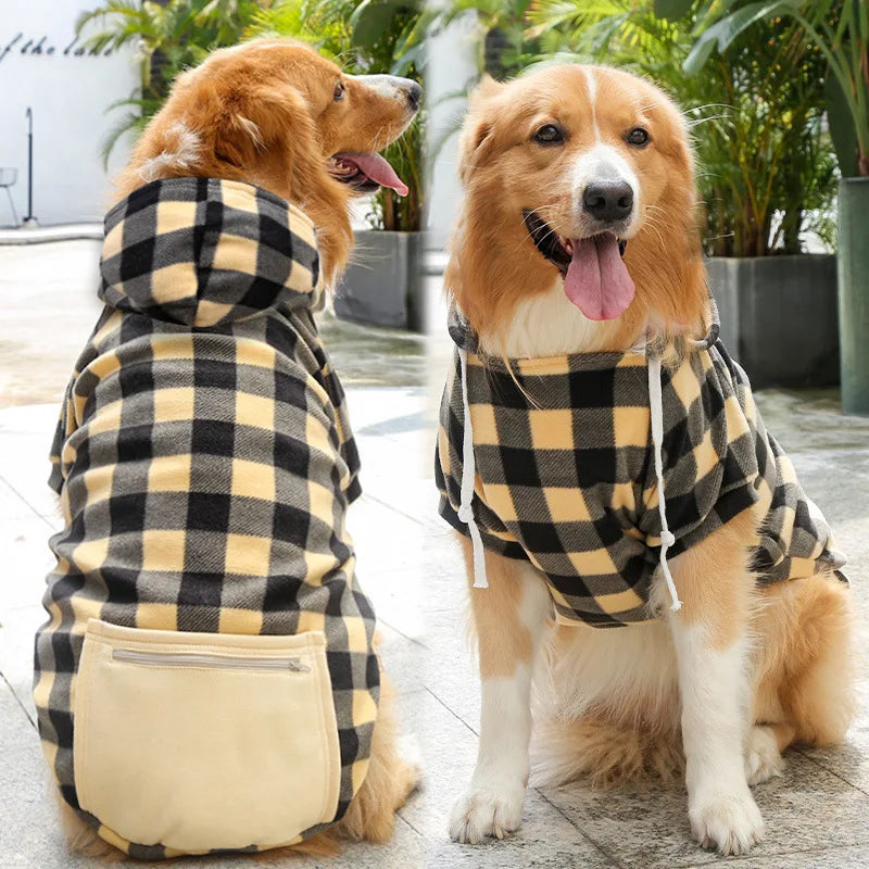 A dog wearing a reversible plaid winter jacket with tan and black checkered pattern.