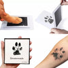A handprint kit showing a paw print on paper and an inked paw print on skin.