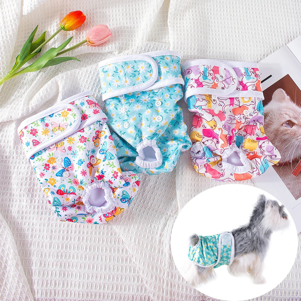 Reusable female dog diapers in various floral patterns with elasticized openings shown on a white fabric background.