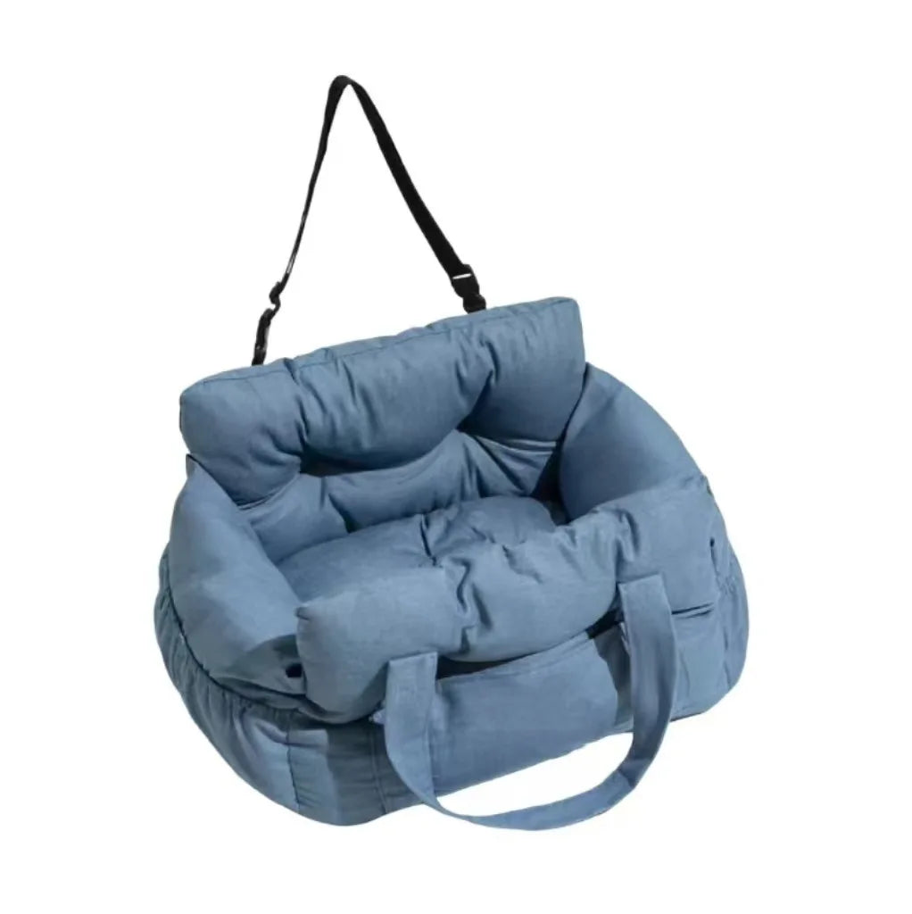 A light blue durable pet car seat with safety straps hanging from a strap.