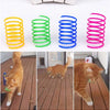 Ein Set bunter Spielsachen zum Frühlingsthema, darunter gelbe, grüne und blaue Ringe, neben drei Katzen, die damit spielen.