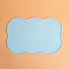 Light blue silicone pet feeding mat with a scalloped edge placed on an orange background.