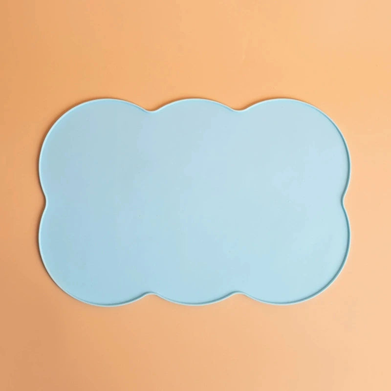 Light blue silicone pet feeding mat with a scalloped edge placed on an orange background.