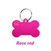 A bright pink bone-shaped dog ID tag with a silver keyring.