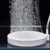 A white aquarium air stone disc diffuser is shown spraying fine bubbles into a clear container.