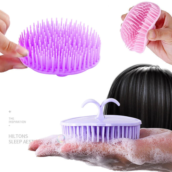 Una mano sostiene un cepillo de masaje para el cabello y el cuero cabelludo de silicona morada con cerdas, demostrando su uso