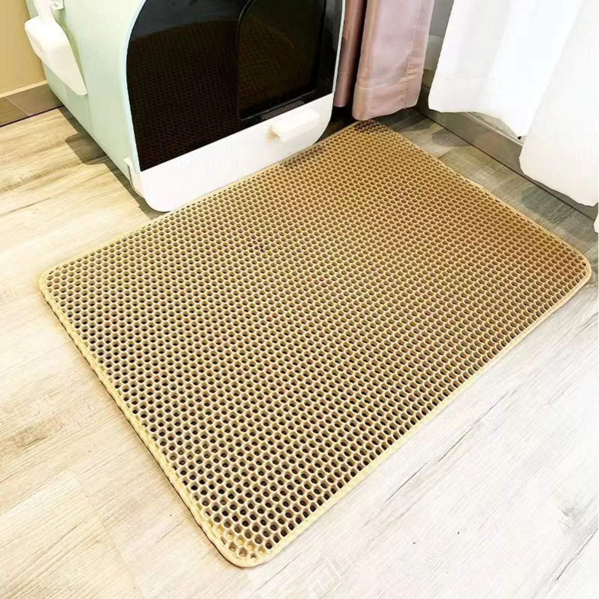 Beige, strapazierfähige, wasserdichte Katzenstreumatte auf einem hellen Holzboden.