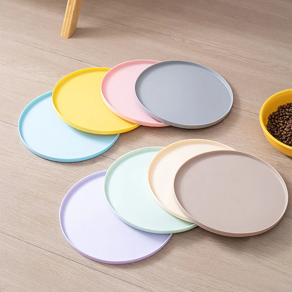 A collection of colorful, round silicone pet feeding mats for dogs and cats arranged on a wooden surface.