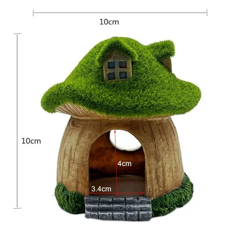 A miniature resin aquarium house decor featuring a green thatched roof and an entrance for small fish.