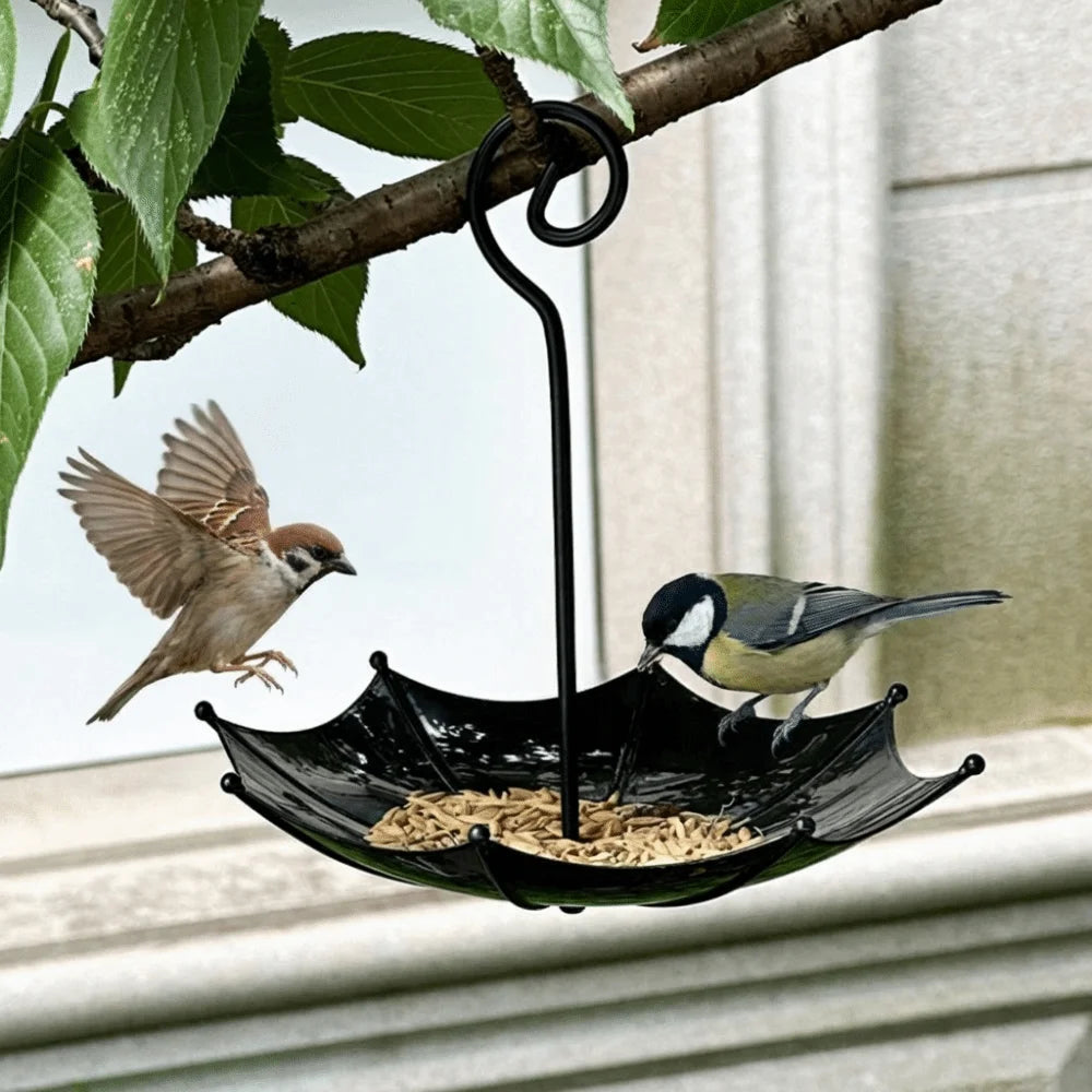 A black umbrella-shaped hanging bird feeder with seeds, featuring a small bird in flight.