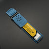 A blue nylon sport band with a silver buckle and a yellow label for a Huawei watch.