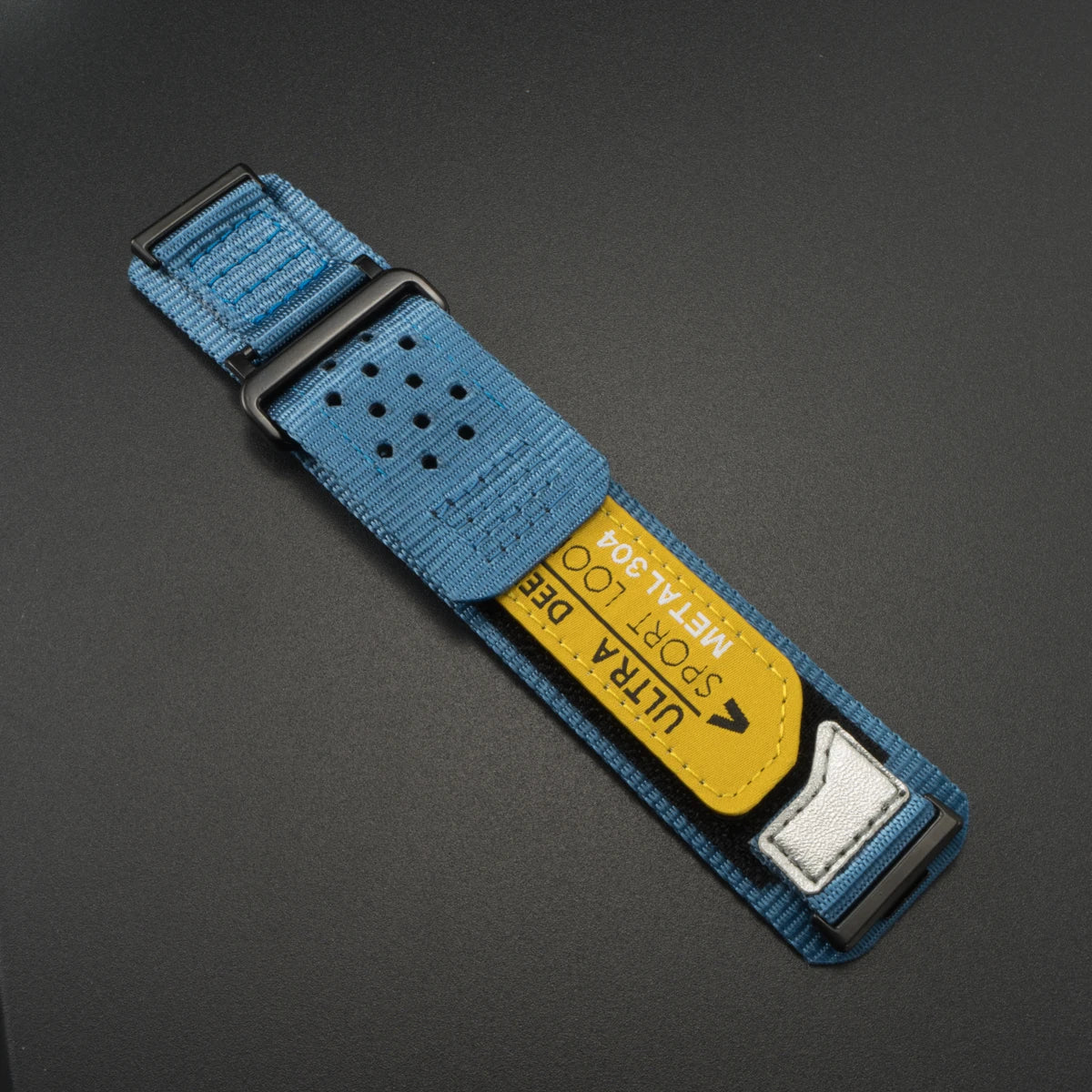 A blue nylon sport band with a silver buckle and a yellow label for a Huawei watch.