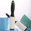 A black and white adhesive lint roller is shown next to a light blue container and a teal fan-shaped object.