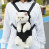 A white fluffy cat is sitting inside a black adjustable carrier backpack worn by a person.