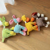 A collection of squeaky donkey plush toys in various colors and textures lying on a wooden floor.
