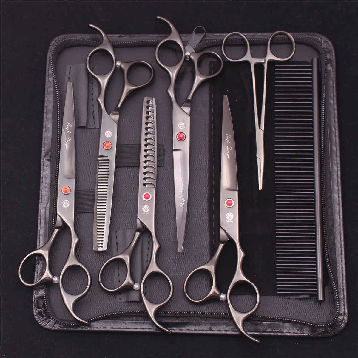 A set of professional stainless steel pet grooming scissors and grooming tools laid out on a black case.