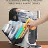 Eine Hand legt klare Plastikbecher in einen seitlich montierten Organizer für eine Ninja-Slushie-Maschine.