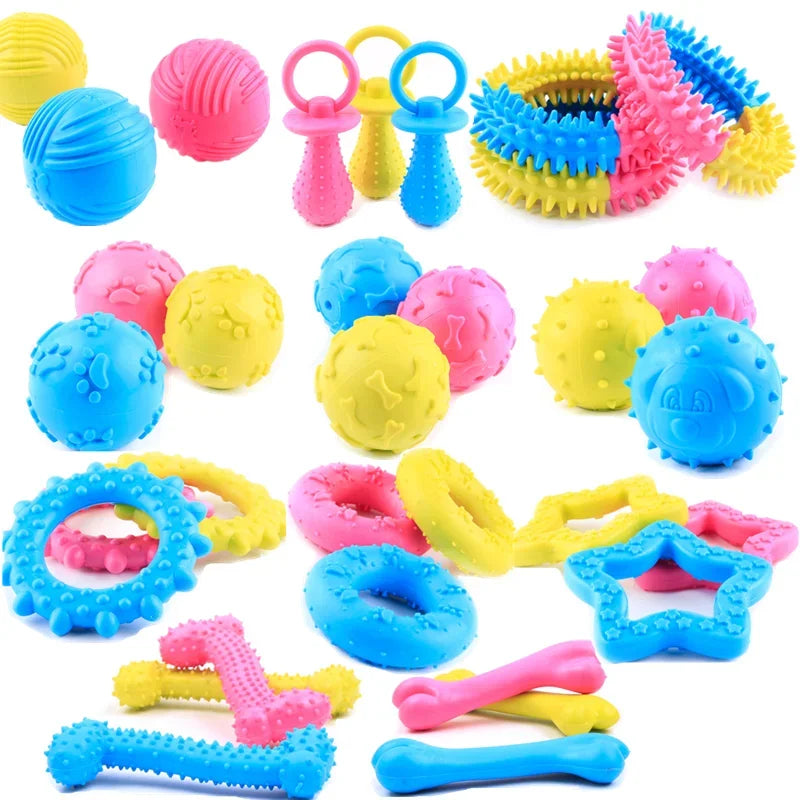 A collection of colorful rubber chew toys and teething rings for small dogs, including balls, chew tubes, and various shapes.