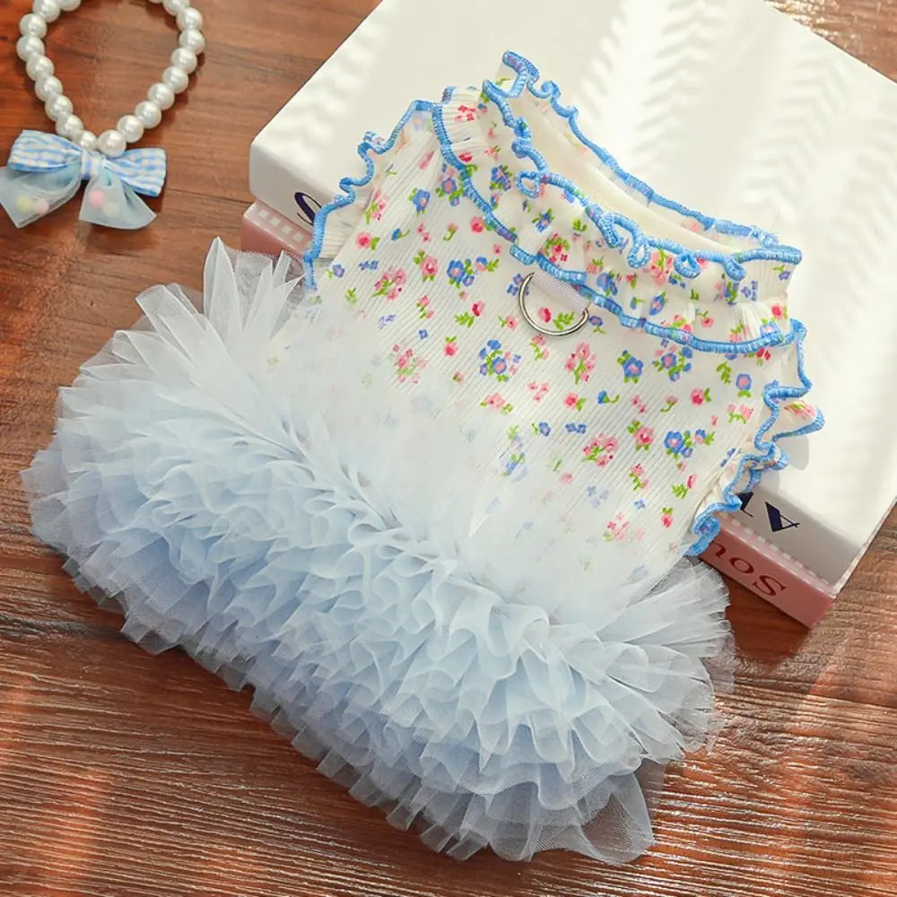 A light blue floral princess pet dress for dogs and cats displayed on a wooden surface.
