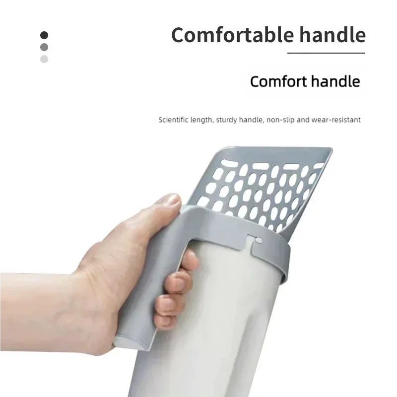 A hand is holding a gray integrated cat litter scoop and poop pick-up tool.