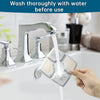 A hand is washing a square, translucent filter replacement for a cat water fountain under running tap water.