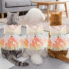 Three pets wearing colorful rainbow butterfly pet dresses sitting on a floor