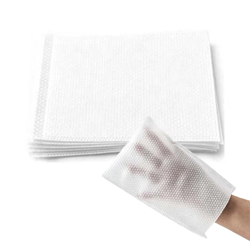 Guante desechable para quitar pelo de mascotas en una mano, junto a una pila de guantes blancos similares.