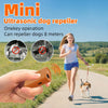 A woman is using a portable ultrasonic dog repeller device to deter dogs on a path.