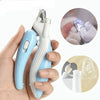 A hand holds a light blue pet nail clipper and its components, showing the clippers and a separate LED light tool.