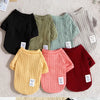 A collection of knitted winter sweaters for dogs and cats in various shades of green, yellow, pink, and red.