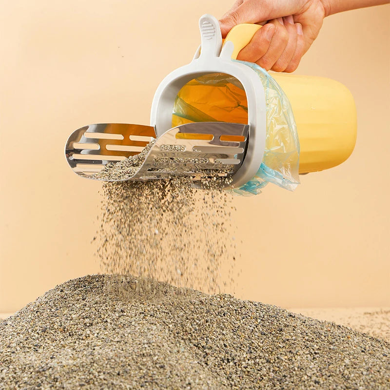 A hand is using a stainless steel cat litter shovel with a clear refill bag to pour dry litter onto a pile of granular materi