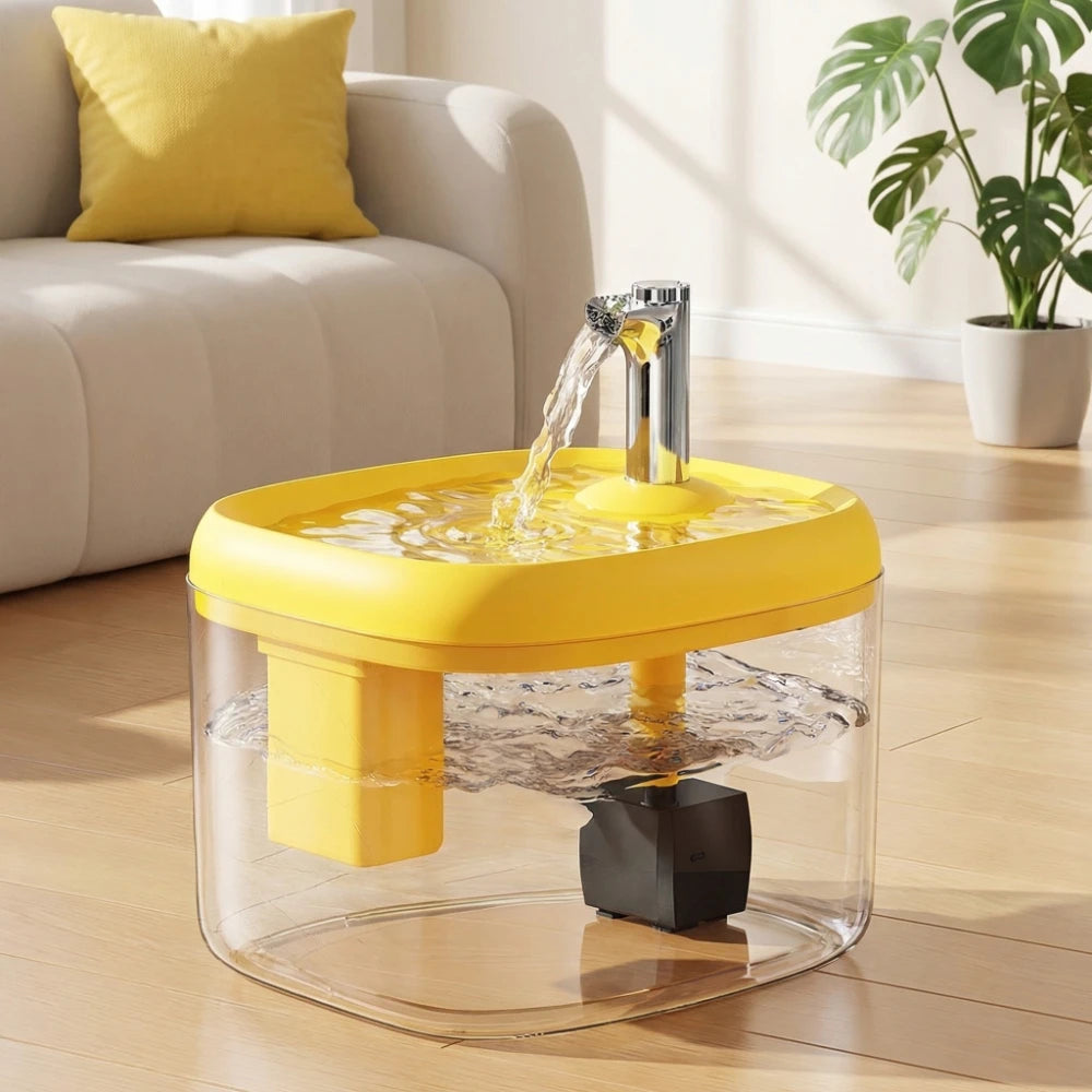 Fontaine à eau automatique jaune avec un bol transparent sur un plancher en bois.