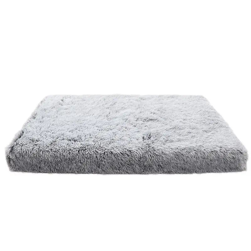A rectangular, gray ultra plush orthopedic dog bed with a fluffy texture.