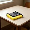 Serviette de bain ultra-absorbante jaune pour animaux pliée sur une table en bois clair.