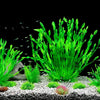 A vibrant display of artificial aquatic plants in various shades of green and pink growing on a light gravel substrate.
