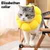 A gray and white cat wearing a yellow soft plush Elizabethan collar.