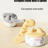 Yellow silicone pet can opener and feeding spoon with a sealing lid shown next to its container.