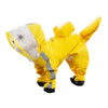Un cachorro de perro amarillo con impermeable gris, visto de cuerpo completo.