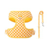 A yellow and orange checkered no-pull dog harness with a leash for small dogs.