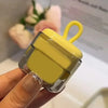 A hand holds a yellow portable lint roller with a clear casing and a yellow handle, used for pet hair removal.