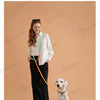 A woman is holding a colorful dog leash connected to a white dog, demonstrating the pet leash.