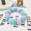 A colorful pet collar and bow tie set featuring fuzzy purple and blue flowers arranged in a circle.