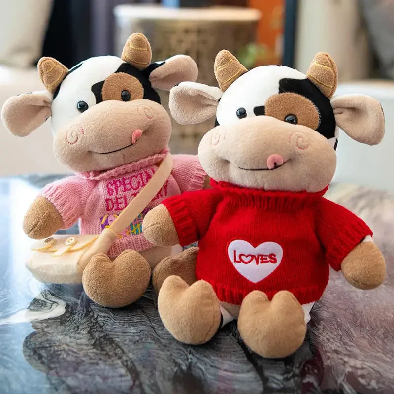 A plush toy of a cow with black and white markings, featuring pink and red clothing.