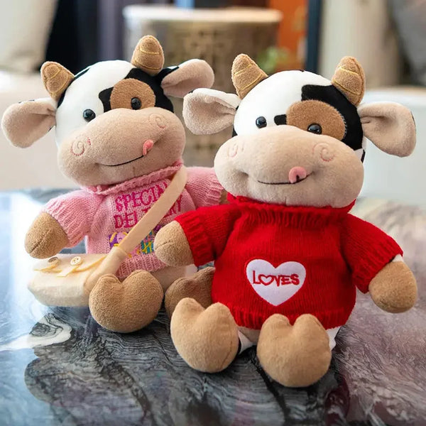 A plush toy of a cow with black and white markings, featuring pink and red clothing.