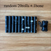 A row of black dog waste bags is displayed on a wooden surface next to a black dispenser.