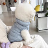 Ein flauschiger weißer Hund- oder Katzenmantel wird in den Schoß einer Person gehalten.