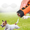A hand holds an orange ultrasonic dog bark deterrent trainer, with a white dog running nearby.