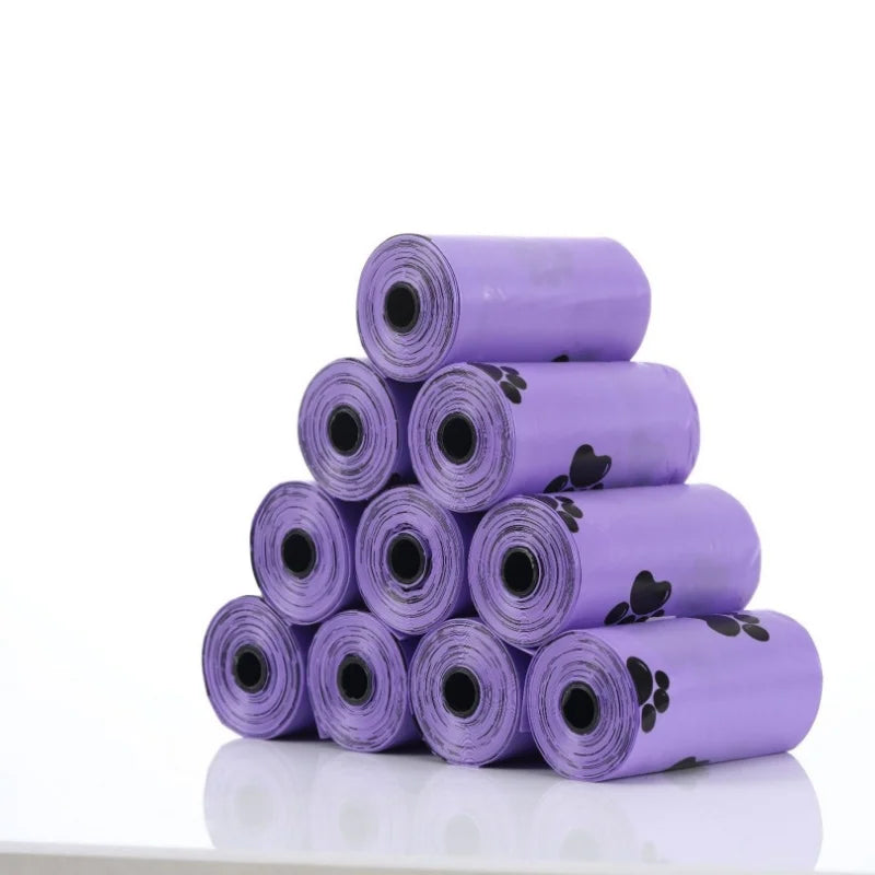A stack of twenty rolls of purple biodegradable dog waste bags with a dispenser.