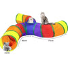 Buntes zusammenklappbares Katzentunnel mit verschiedenen farbigen Abschnitten, in dem eine Katze spielt.